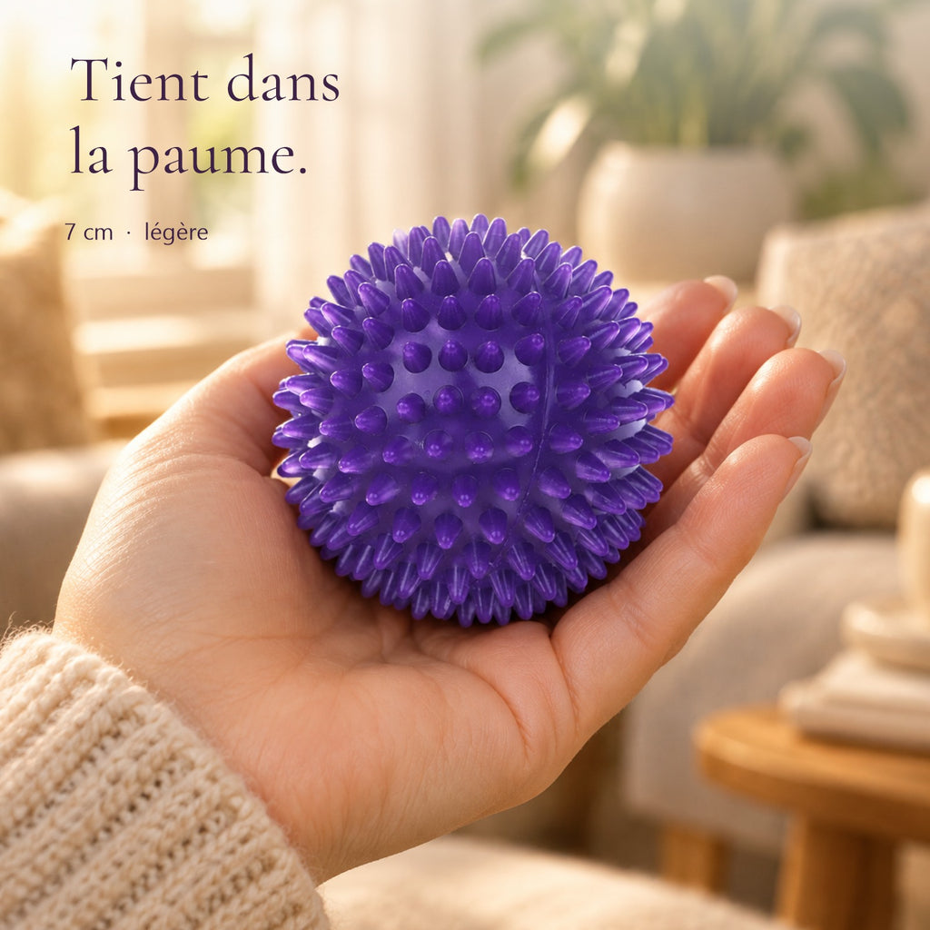 Balle de massage à picots violette de 7 cm tenue dans la paume de la main