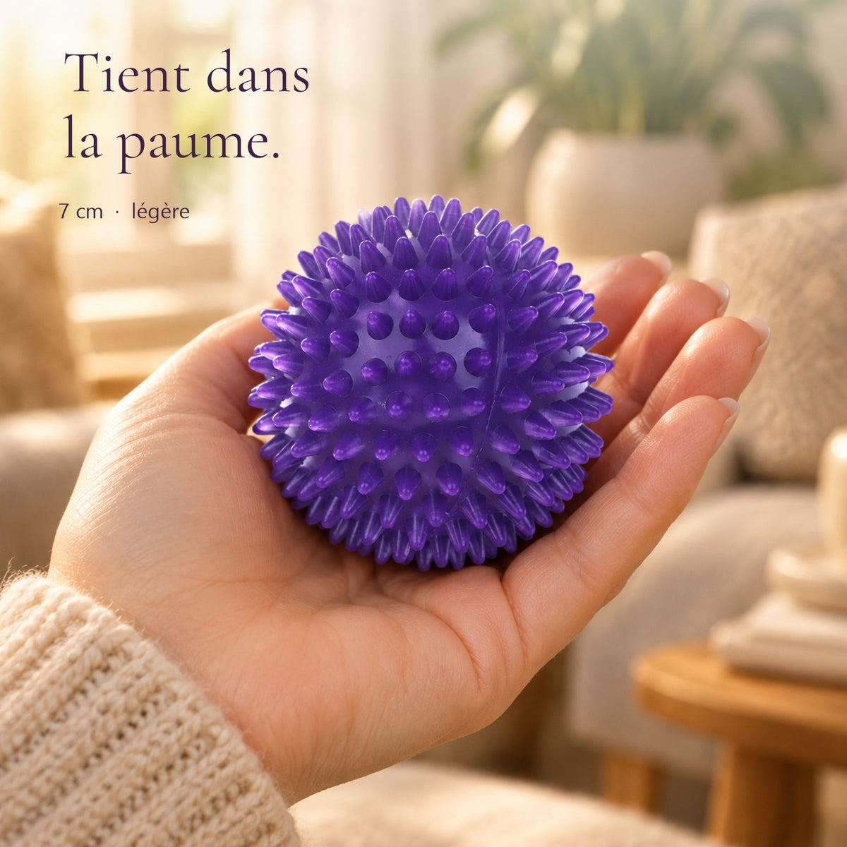 Balle de massage à picots violette de 7 cm tenue dans la paume de la main